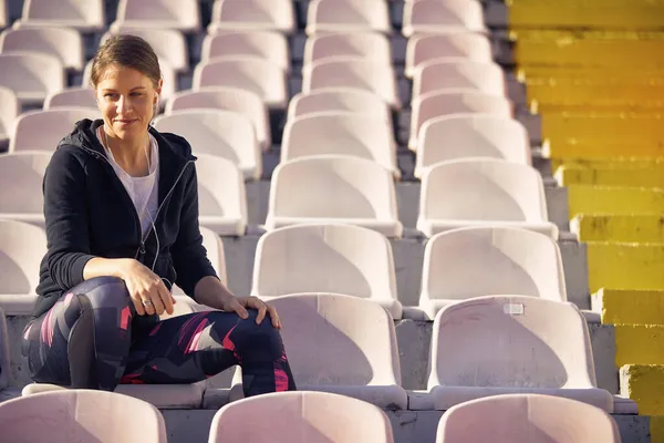 Красивая Молодая Белая Женщина Сидящая Стадионе Наушниками Ушах Улыбающаяся Разговаривающая — стоковое фото