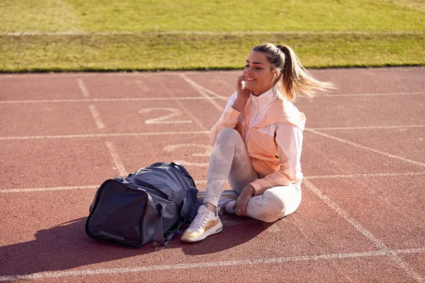 Hermosa Mujer Adulta Joven Sentada Pista Atleta Estadio Con Auriculares — Foto de Stock