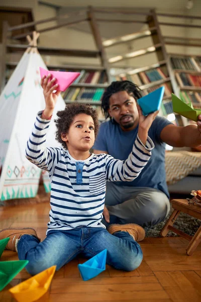 父亲和儿子喜欢在家里轻松的气氛中一起玩纸船 游戏时间 — 图库照片