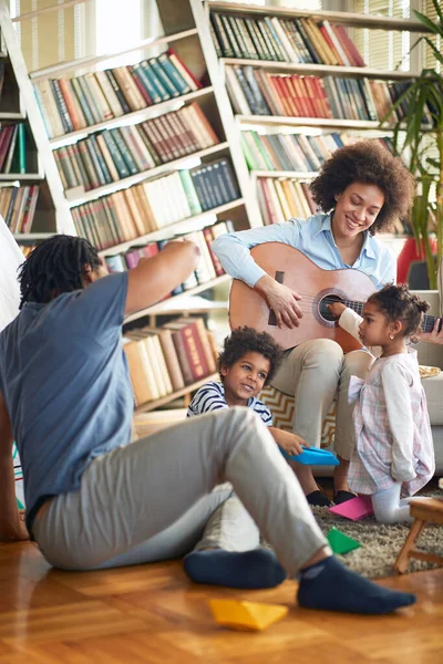 年轻的家庭在家里愉快地享受着吉他和音乐 游戏时间 — 图库照片