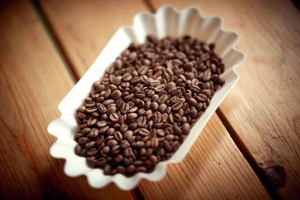 将香喷喷的咖啡豆和香喷喷的咖啡豆放在桌子上的容器中进行特写 — 图库照片