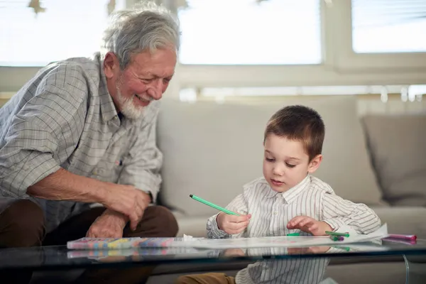 小さい孫は おじいちゃんと家でリラックスした雰囲気の中で上質な時間を過ごしながら絵を描くことを楽しんでいます 遊び時間 — ストック写真