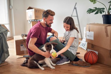 Yeni evlerinde köpekleriyle gülümseyen bir çift