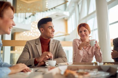 Genç ofis çalışanları yemek yiyor ve tartışıyorlar.