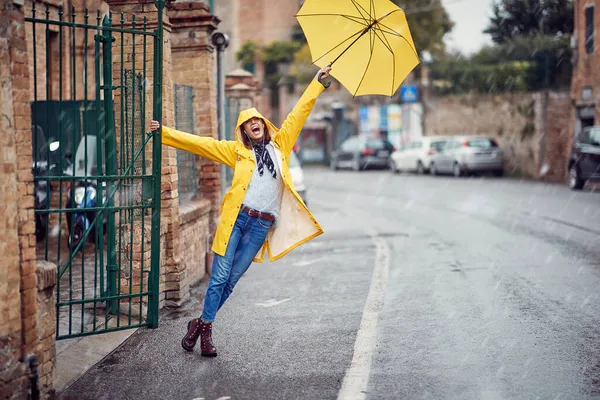 Ein Junges Mädchen Mit Gelbem Regenmantel Und Regenschirm Amüsiert Sich — Stockfoto