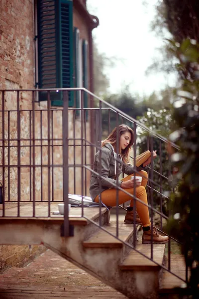 Молодая Красивая Женщина Сидит Лестнице Перед Домом Читает Книгу Непринужденной — стоковое фото