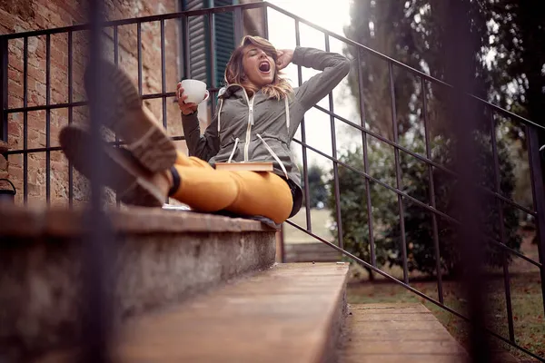 Genç Yakışıklı Bir Kadın Evin Önündeki Merdivenlerde Oturup Rahatlamış Bir — Stok fotoğraf