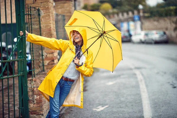 Ein Junges Mädchen Mit Gelbem Regenmantel Und Regenschirm Amüsiert Sich — Stockfoto