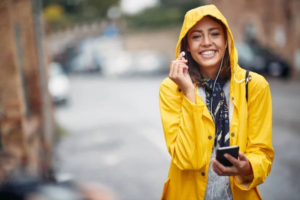 Ragazza Sorridente Con Impermeabile Giallo Ascolta Musica Sotto Pioggia — Foto Stock