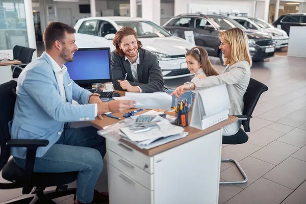 Salesman Dan Keluarga Dealer Mobil Saloon Menunjukkan Kontrak Untuk Mobil — Stok Foto