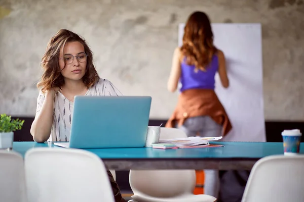 年轻的女雇员集中在办公室的工作环境中工作 — 图库照片