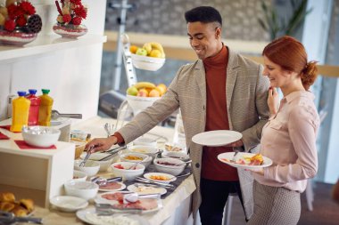 İki yakışıklı iş arkadaşı ofiste kahvaltı yapıyor.