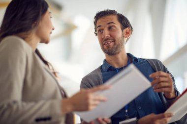 Genç ve yakışıklı bir iş adamı, genç bir bayan meslektaşıyla dostane bir ortamda hoş bir sohbet eder. İş, insanlar, şirket.