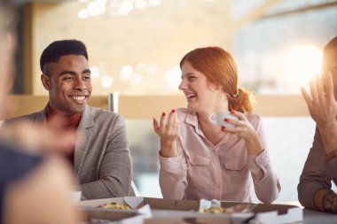 Bir grup genç iş adamı iş yerinde öğle yemeği arasında keyifli bir atmosferde dostça sohbet ediyorlar. İş, insanlar, şirket.