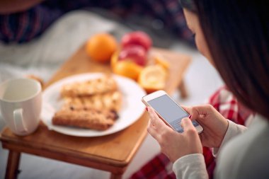 Genç kız sabah cep telefonunda mesaj atıyor.