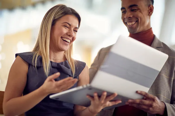 一位年轻的女商人和她的年轻男同事在友好的气氛中 一边笑一边看笔记本电脑内容 Business People Company — 图库照片