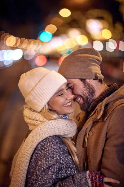 Νεαρός Άνδρας Και Γυναίκα Αγκαλιασμένοι Στέκεται Ένα Δρόμο Διακοσμημένο Χειμερινά — Φωτογραφία Αρχείου