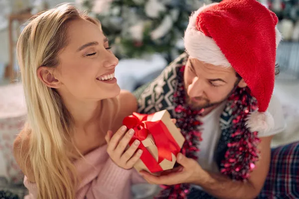 カップル交換クリスマスプレゼント 男与えクリスマスギフト彼の幸せなガールフレンド — ストック写真