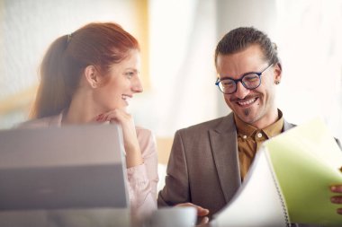 İki genç iş adamı iş yerinde keyifli bir ortamda dostça sohbet ediyorlar. İş, insanlar, şirket.