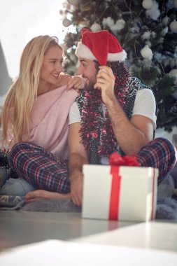 Mutlu çift Noel zamanı evde sarılıyor.