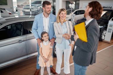 Kafkasyalı mutlu bir aile kendilerine yeni bir araba alıyor.