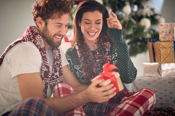 幸せな男と女はクリスマスの朝に贈り物を共有する — ストック写真