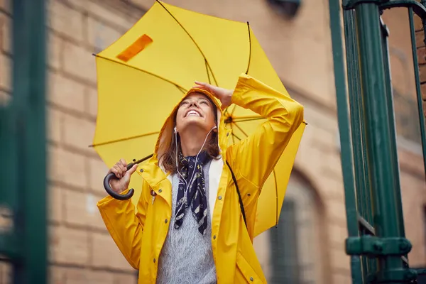 Seorang Wanita Muda Ceria Dengan Jas Hujan Kuning Dan Payung — Stok Foto