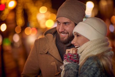 Genç aşık bir çift, güzel bir Noel gecesinde şehrin tadını çıkarıyor. Noel, şehir, ilişki