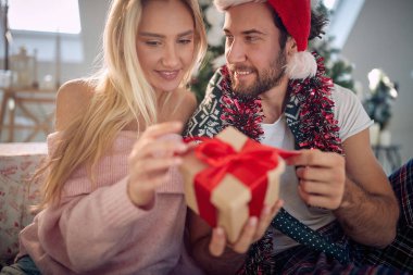 Mutlu çift Noel sabahı hediyelerini değiş tokuş ediyor.