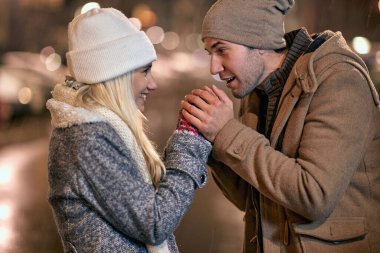 Soğuk karlı bir gece. Romantik erkek ve kadın kışın dışarıda.