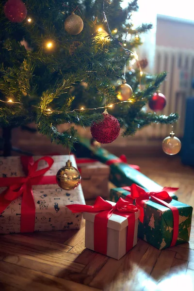クリスマスの夜に木の下でプレゼントを包んだ — ストック写真
