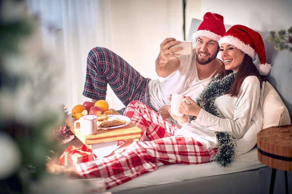 ハッピーカップルはクリスマスの朝一緒に目を覚ます — ストック写真