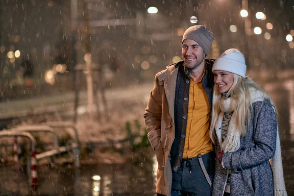 雪の夜に幸せなカップルや街の通りを歩く — ストック写真
