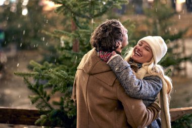 Birlikte kış gecesinin tadını çıkaran neşeli çift; şenlikli konsept.