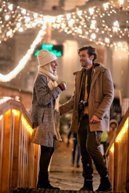 Sıcak çay içen mutlu adam ve kadın xmas akşamını birlikte geçiriyorlar.