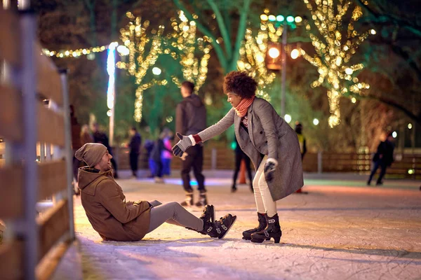 Girl Helping Her Boyfriend Stand While Learning Skate Ice Skating — Stock Photo, Image