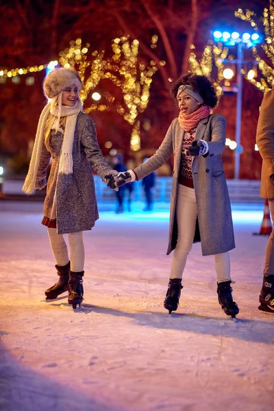 Två Kvinnliga Vänner Håller Hand Medan Skridskoåkning Skridskoåkning Rinken Julen — Stockfoto
