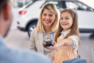 Mutlu aile, yeni bir araba ararken oto tamirhanesinde hoş bir atmosferde iyi vakit geçiriyor. Araba, alışveriş, alışveriş.