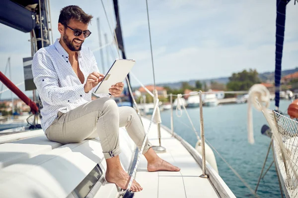 Young Man Enjoying Tablet Content While Sitting Yacht Riding Dock — Stock Photo, Image