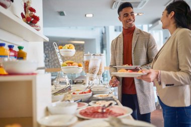  İş arkadaşları ofis kafeteryasında öğle yemeği yiyor.