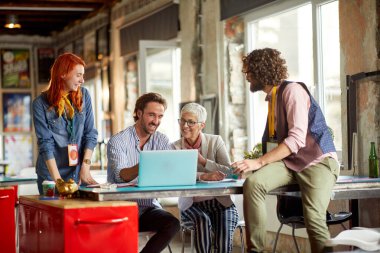 Kafkas insanları, farklı yaş ve cinsiyetler, açık uzay ofisinde birlikte çalışıyorlar.