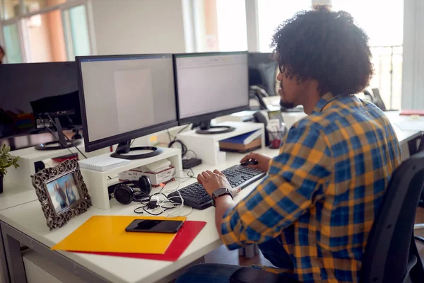 若いアフリカ系アメリカ人の男性プログラマーがオフィスで働いています — ストック写真