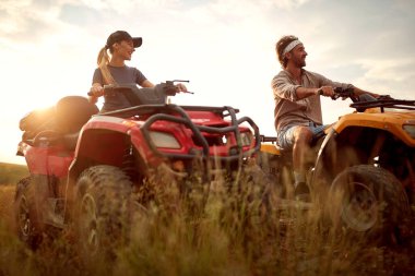 Genç bir adam ve kadın dörtlü bir araçla eğleniyorlar. 
