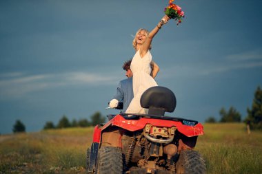 Mutlu gelin buketi havaya fırlatıyor. Neşeli yeni evli çift avluya biniyor. Aşk, evlilik, düğün, mutluluk, çift kavramı.