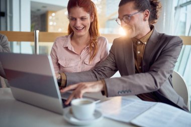 Genç bir iş adamı, şirket binasındaki hoş bir atmosferde dizüstü bilgisayarın keyfini çıkarırken kadın meslektaşıyla iyi vakit geçiriyor. İş, insanlar, şirket.