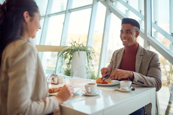 若い実業家が若い女性の同僚と食堂でリラックスした雰囲気の中で昼食休憩を楽しんでいます ビジネス — ストック写真