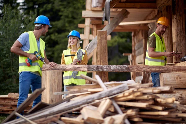 Unga Glada Byggnadsarbetare Som Arbetar Med Trähuskonstruktion Träskelett Inramningsbyggnad Byggindustri — Stockfoto