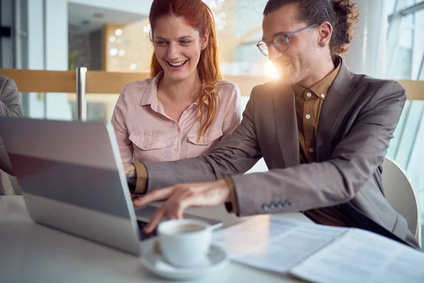Genç bir iş adamı, şirket binasındaki hoş bir atmosferde dizüstü bilgisayarın keyfini çıkarırken kadın meslektaşıyla iyi vakit geçiriyor. İş, insanlar, şirket.