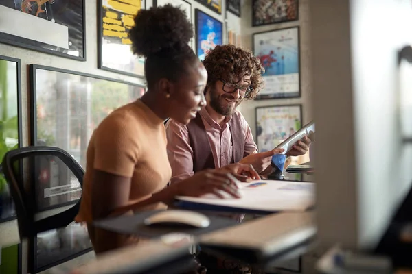 Young Enthusiastic Colleagues Doing Paperwork Togetherin Office — Stock Photo, Image