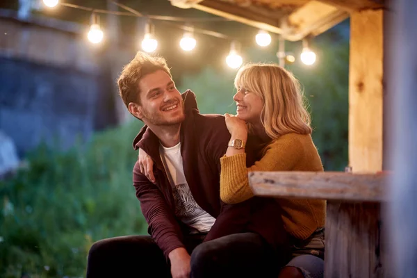 笑着的年轻夫妇在大自然的平台上的木屋里放松一下 — 图库照片